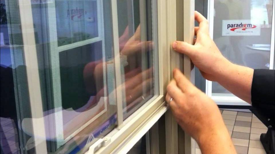 A hand adjusting a window at a Paradigm showroom.